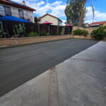 Citrus Bloom Landscape crew smoothing freshly poured cement for a patio or walkway.