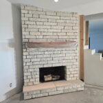 Citrus Bloom Landscape team constructing a red brick fireplace for an outdoor living space.